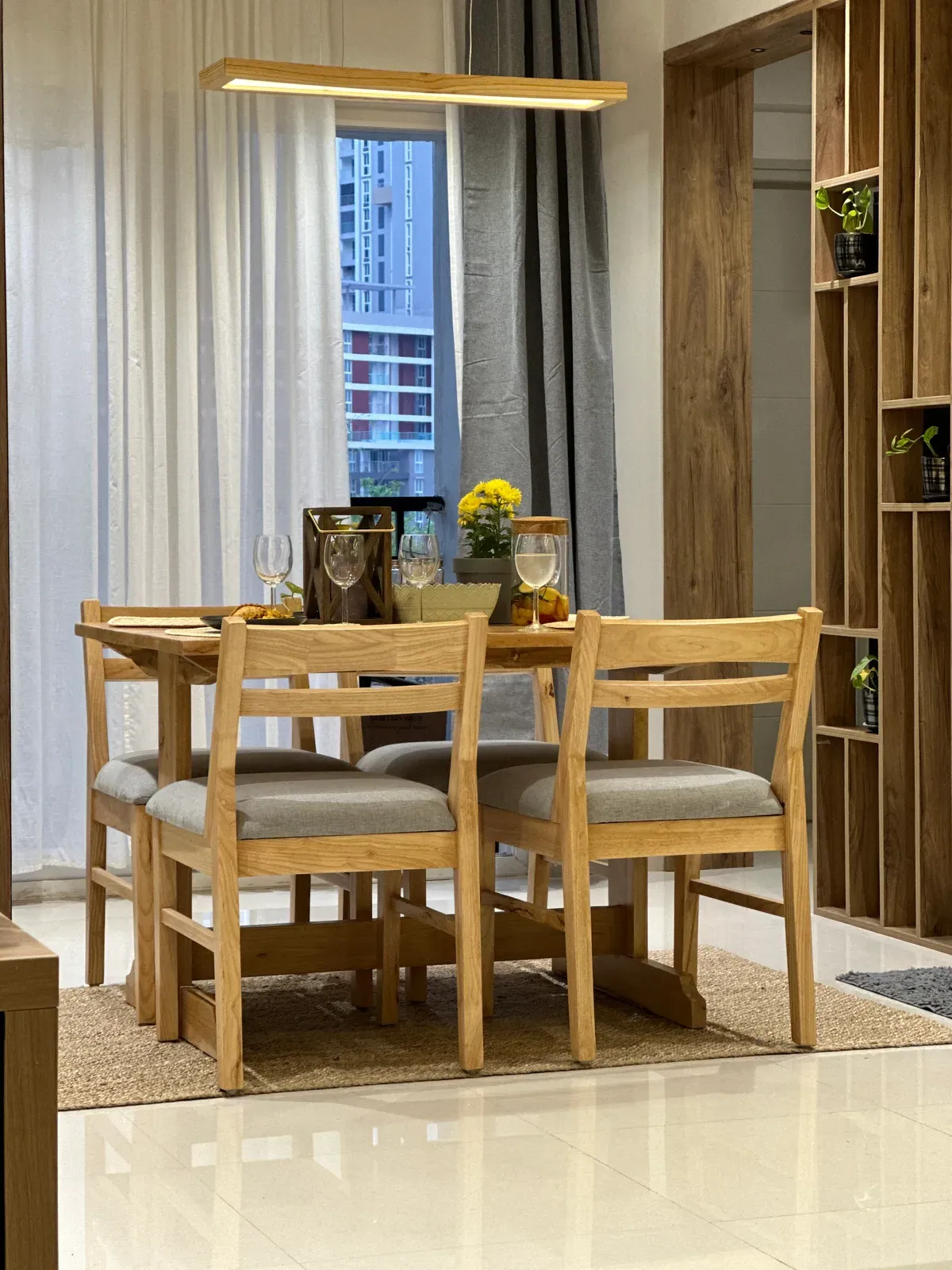 Oak dining set beside shelving and a window — The Aakar